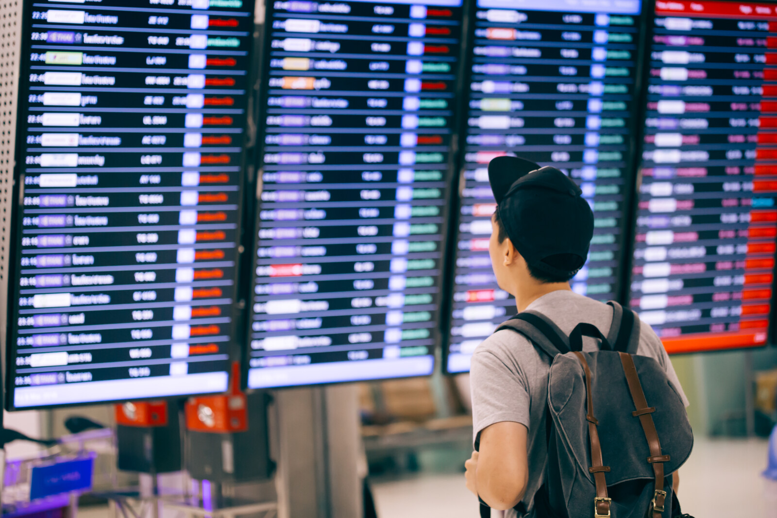 Traveler checking flight information on departure board at the airport